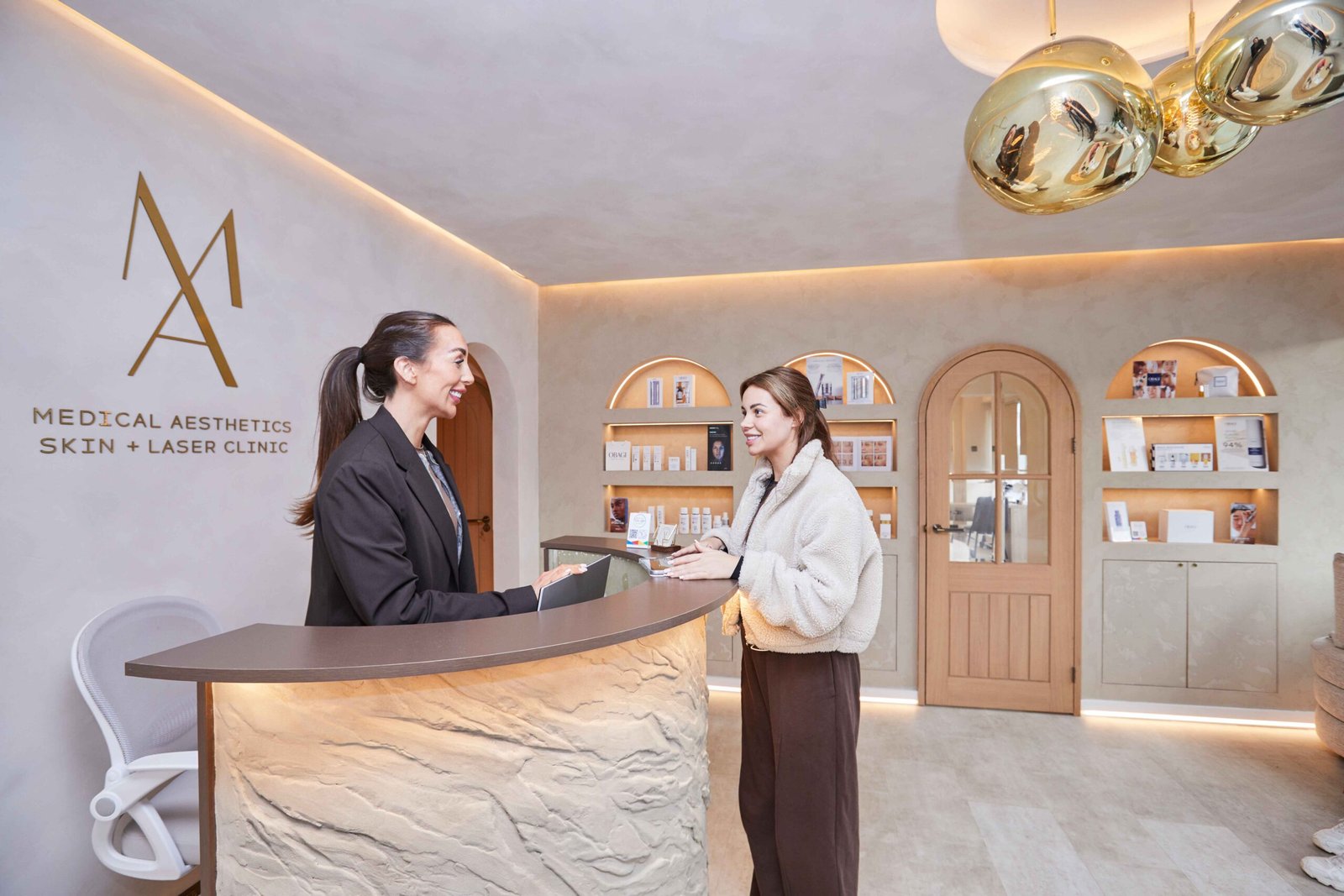 Reception area inside Manchester Aesthetics clinic with staff welcoming a client