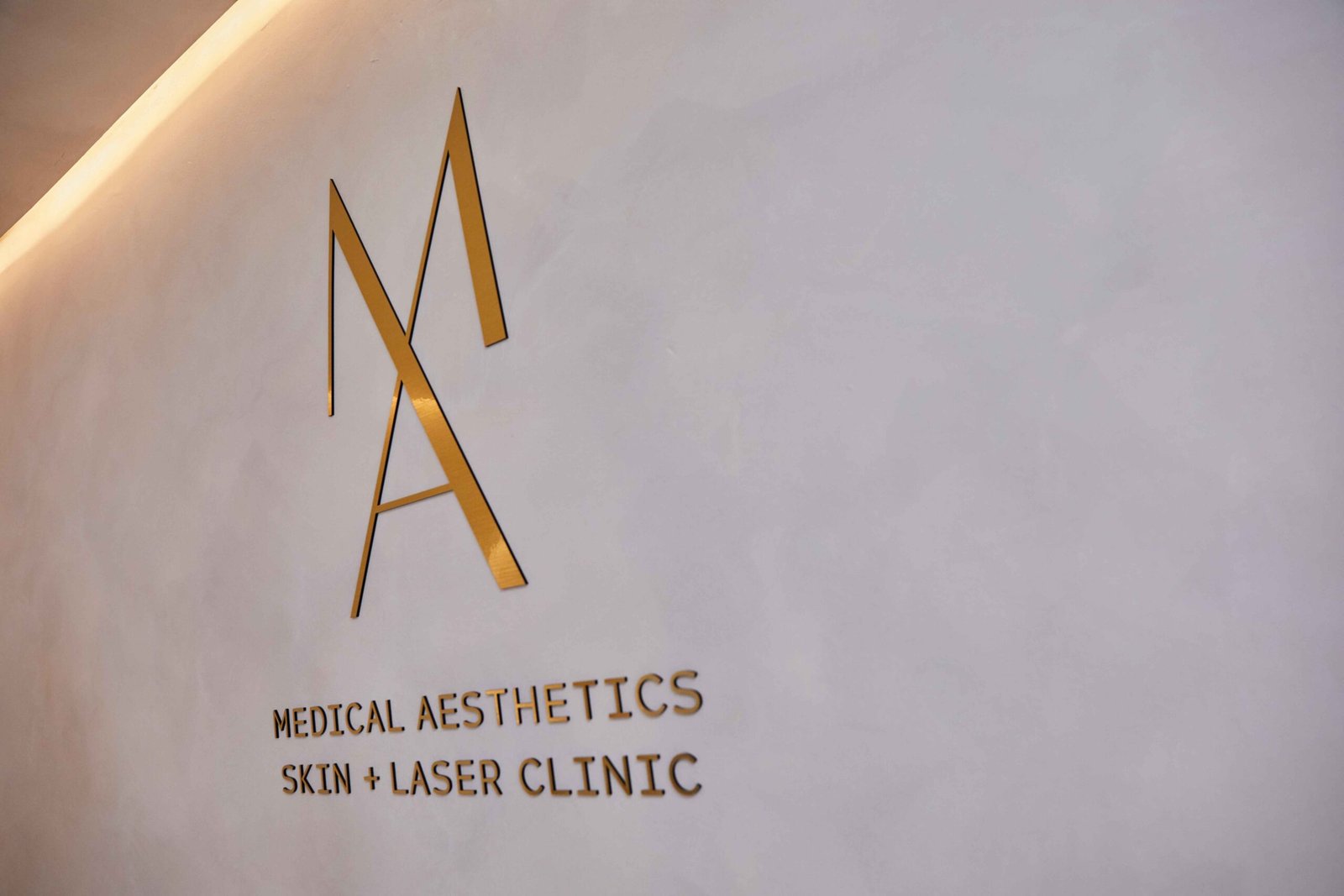 Manchester Aesthetics wall logo displayed behind the clinic reception desk